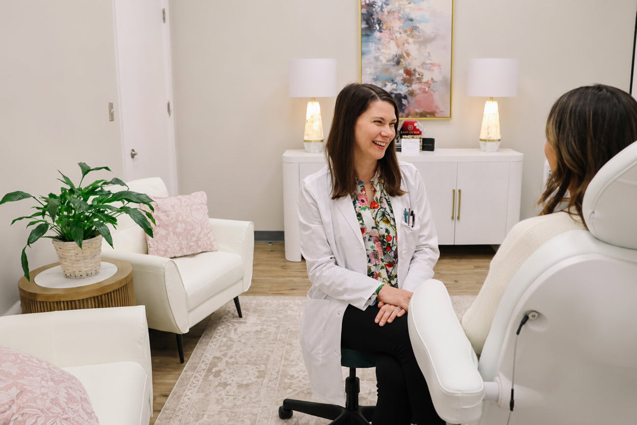Female patient speaking with dermatologist in a modern cosmetic dermatology clinic.